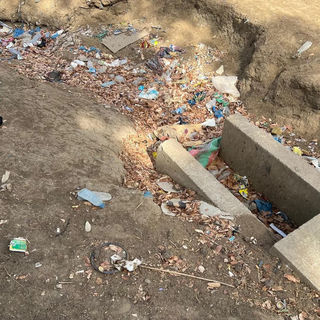 Caniveau maçonné engorgé de déchets avant le curage