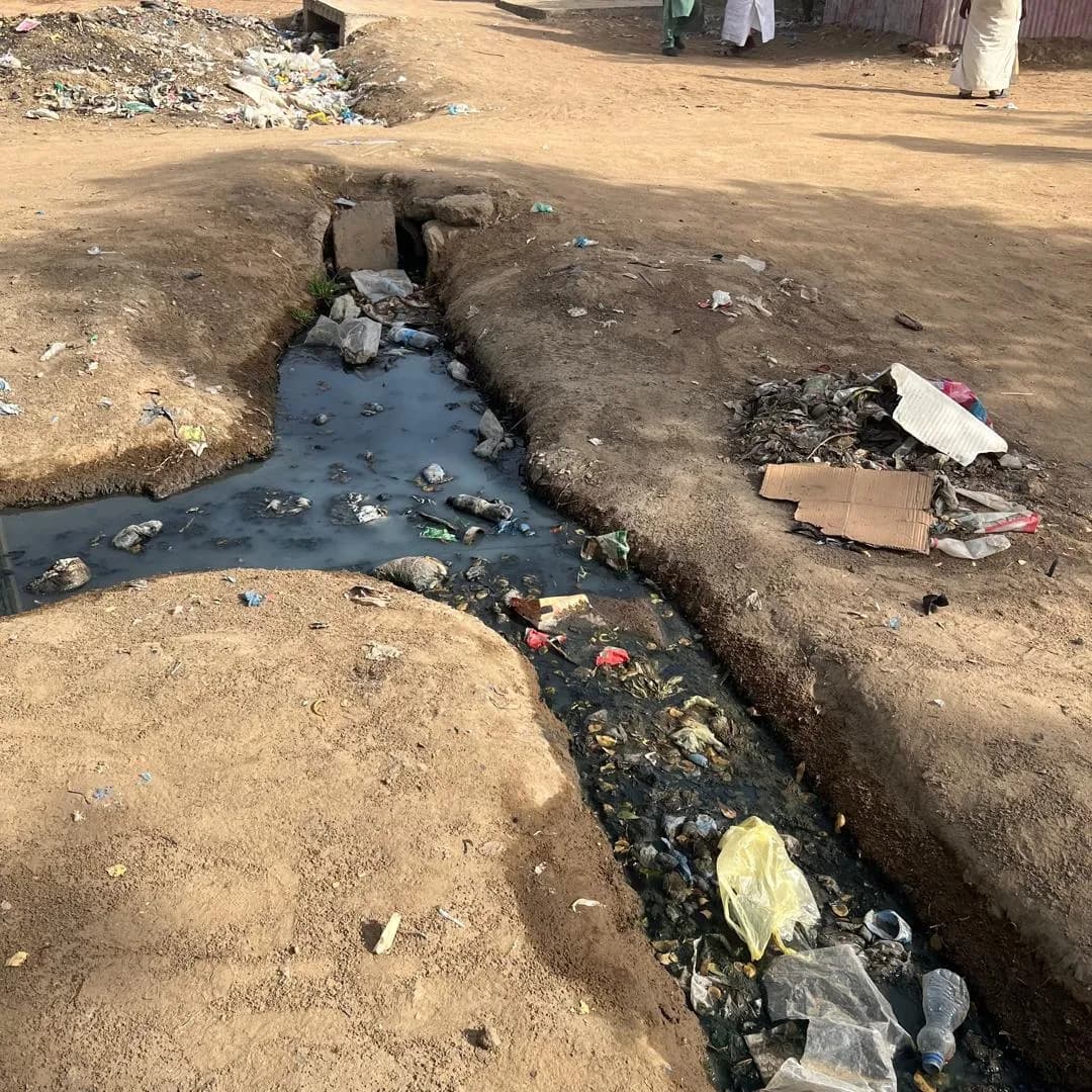 Eaux stagnantes noires dans un caniveau de quartier